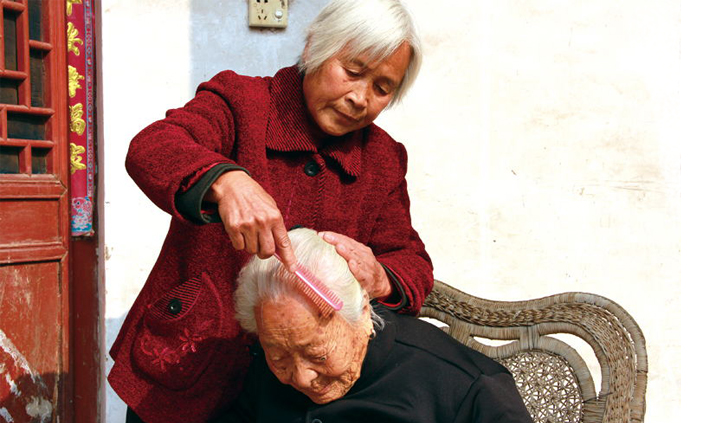为更好照顾婆婆，赵枝妮自学理发、护理。图为她给婆婆梳头发。.jpg