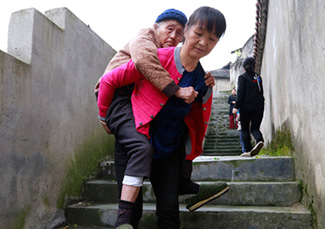 吕正芳背婆婆下阶梯。图片来源：湖南文明网-通讯员-彭伟摄.jpg